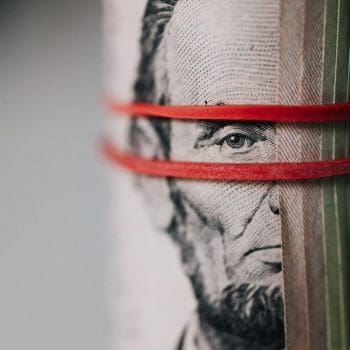 Close-up of a roll of money tied together with a rubber band