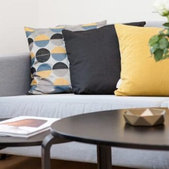 A living room couch with tables set in front of it