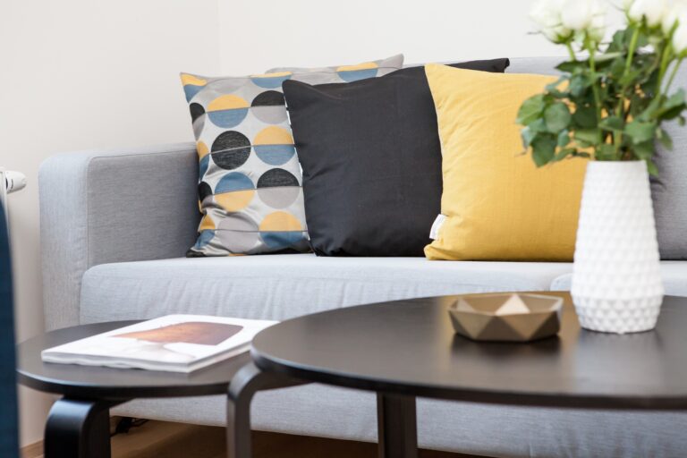 A living room couch with tables set in front of it