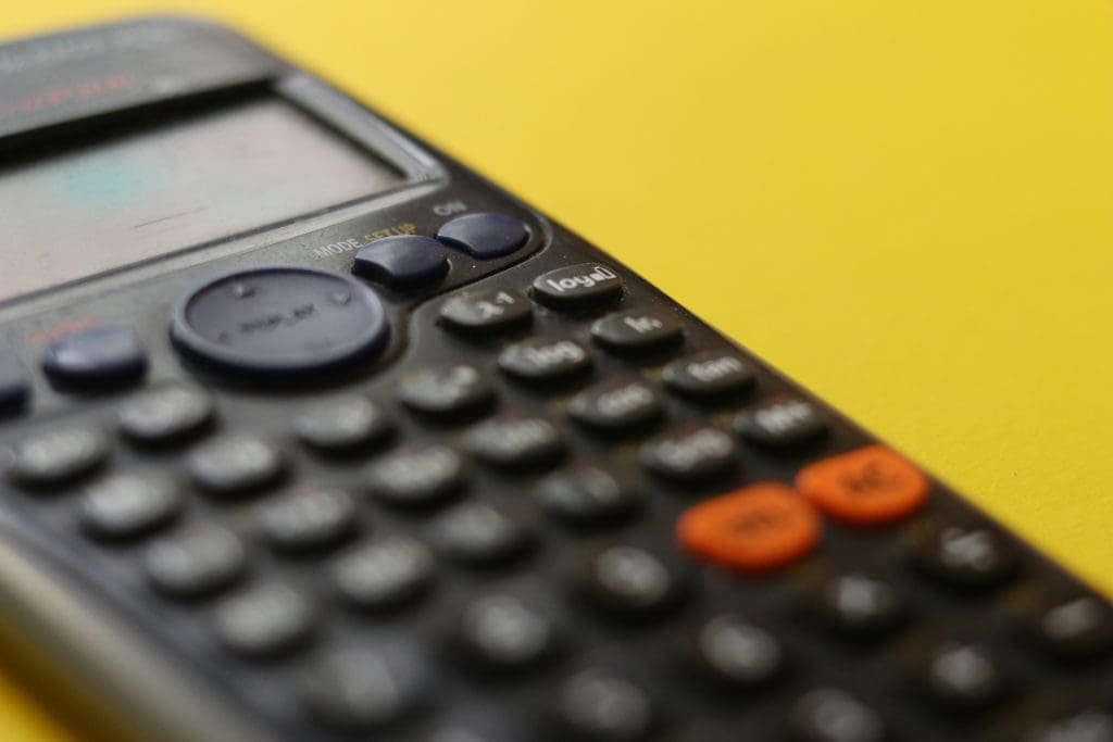 Close up of a calculator against a yellow background