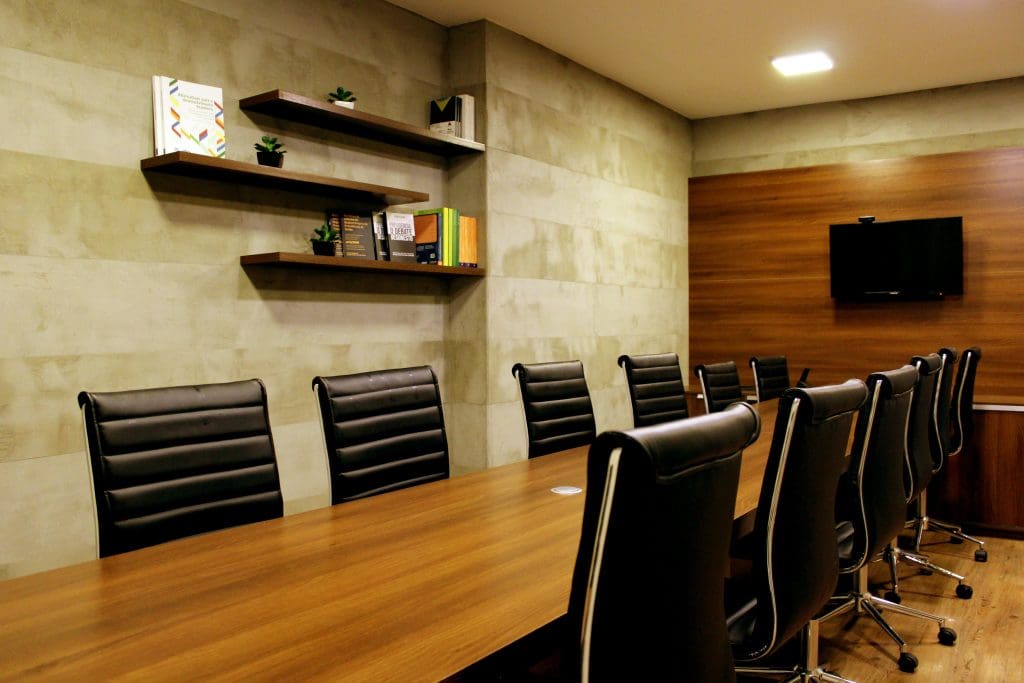 Chairs pushed up against the side of a long desk in a meeting area