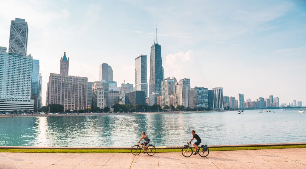 A wide shot of the Chicago skyline with bicyclists and boats visible in the foreground