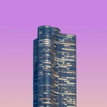 A skyscraper against a purple sky background