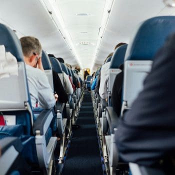 Shot from the center aisle on a plane of passengers in their seats