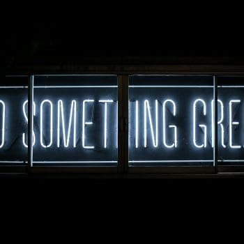 A blue neon sign reading "Do something great"